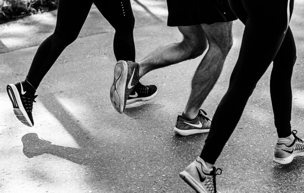black and white photo showing 3 people running